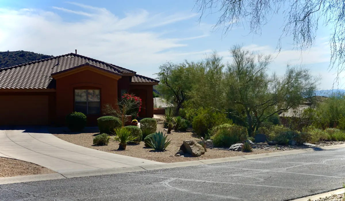 Concrete driveway meeting an asphalt street at a desert-landscaped home – asphalt vs concrete driveways in Riverside heat
