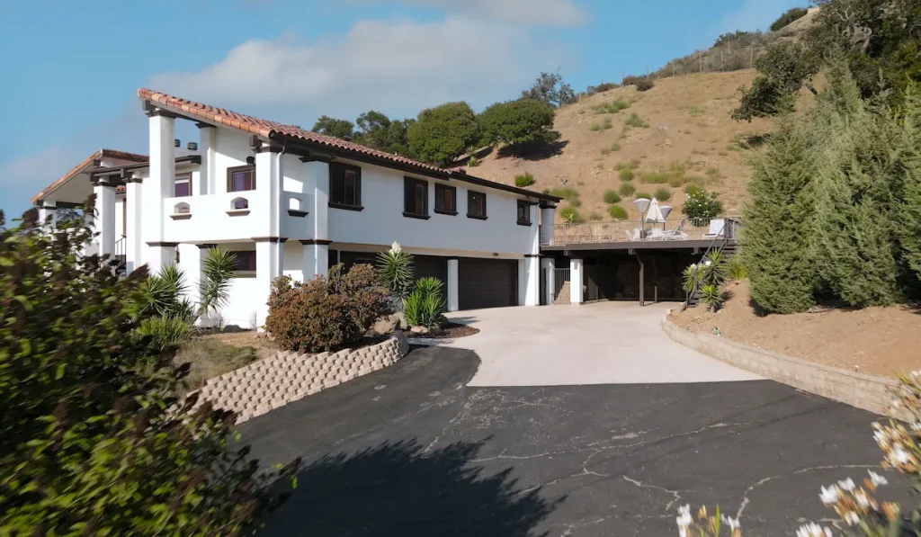 Aging asphalt driveway with surface cracks at a hillside home – how long an asphalt driveway lasts in Riverside, CA